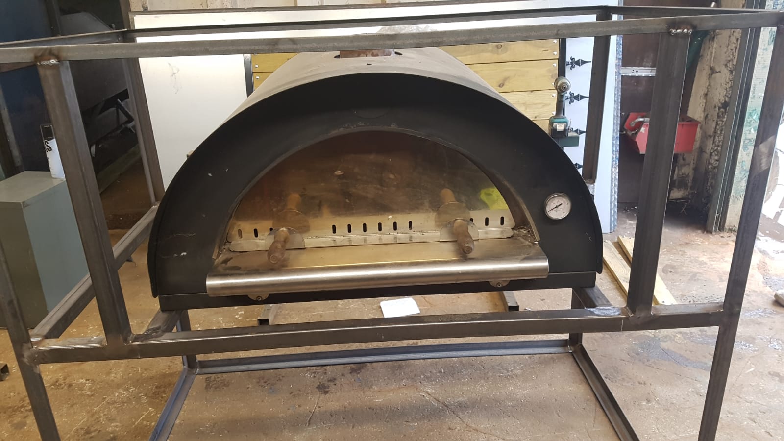 Steel pizza oven stand in workshop