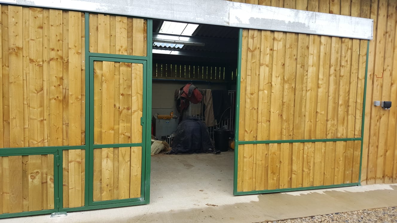 Large green steel barn doors — open