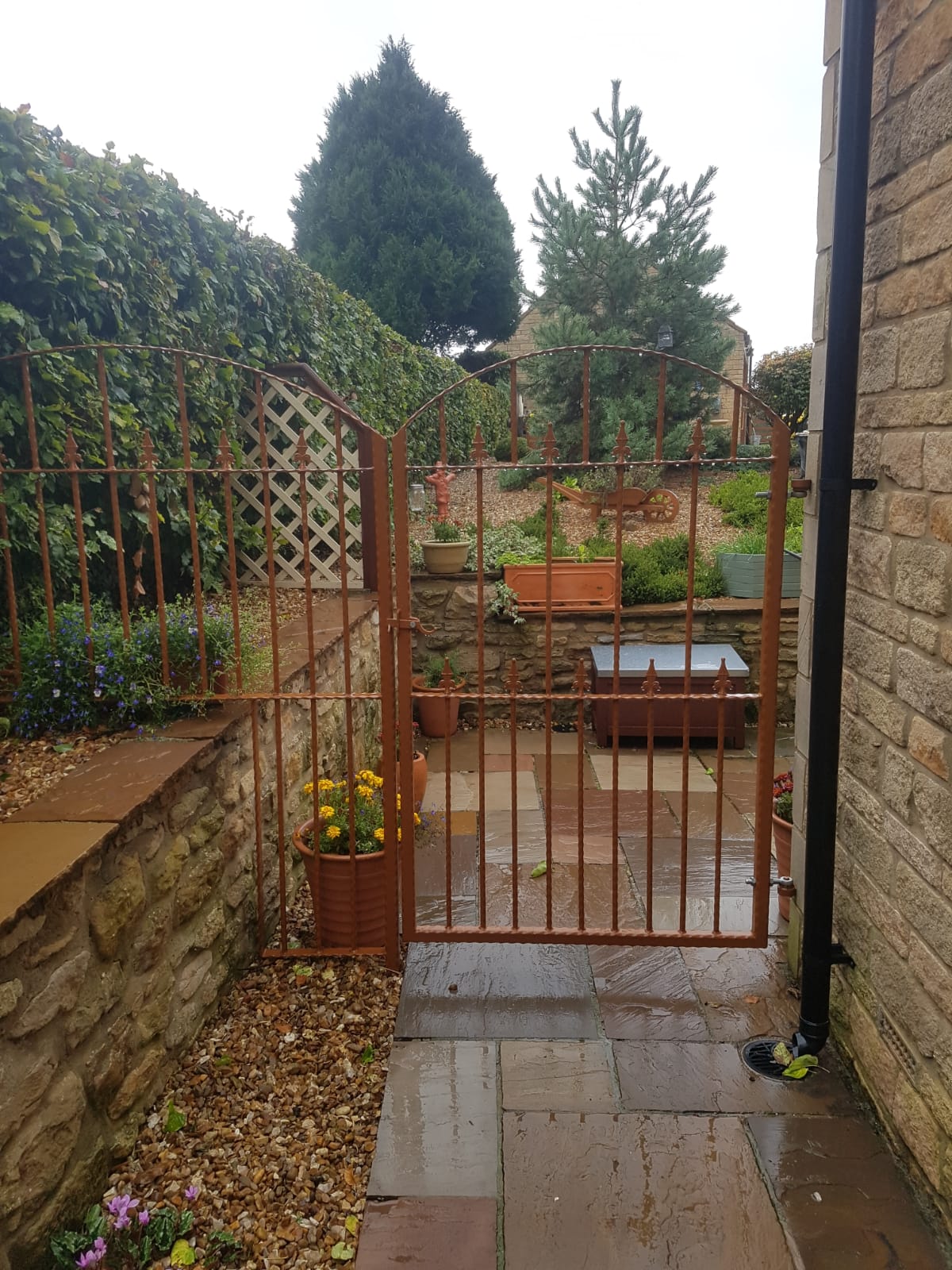 Corten-finish garden gate with arched railings
